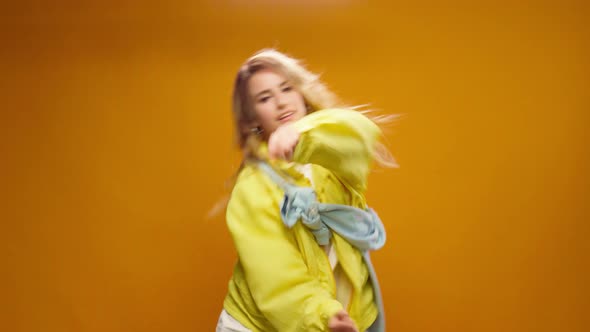 Woman Professional Dancer Dancing in Studio Against Yellow Background