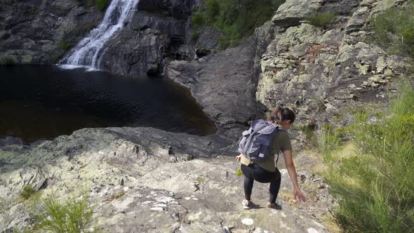 Woman hiking in Fisgas de Ermelo waterfall most beautiful in Portugal