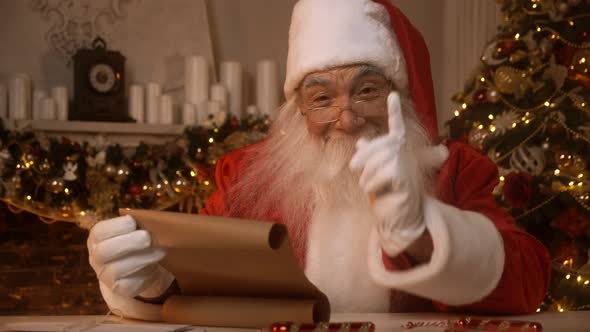 Santa Claus is Reading a List of Nice and Naughty Children in His Residence on North Pole Preparing