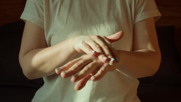 Middle Section of Young Pretty Woman in Casual Clothes Spreading Creme on Her Hands