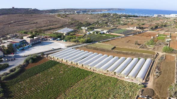 Coastal farmland countryside with silos,Malta seaside,aerial zooming.