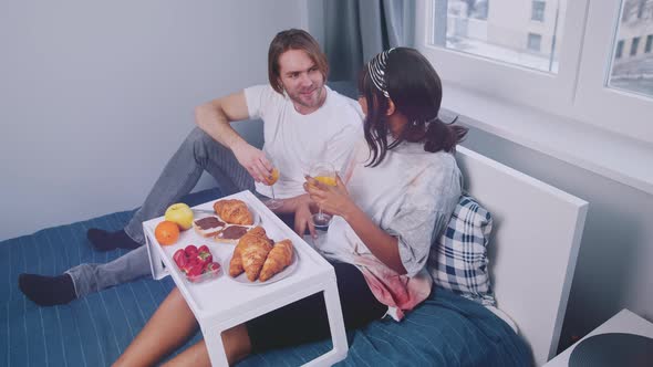 Young Happy Couple Enjoying Breakfast in Bed