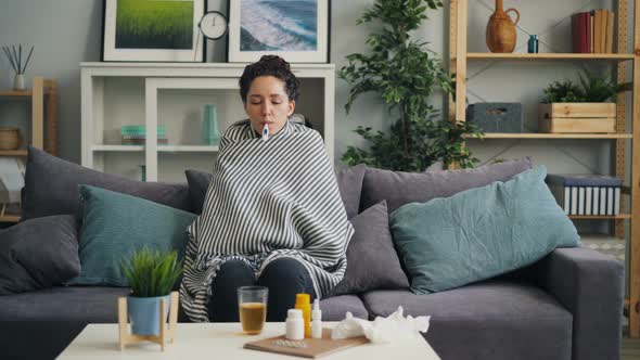 Shivering Girl Student Taking Body Temperature Sitting with Thermometer in Mouth