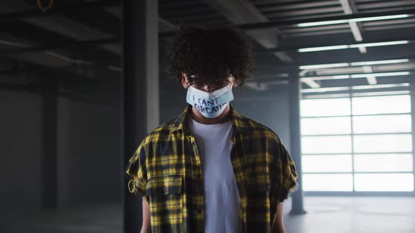 Portrait of mixed race man wearing protest face mask in empty parking garage
