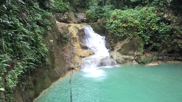 Incredible hidden Mag Aso Falls Philippine waterfall lagoon. Green water lagoon deep in the mountain