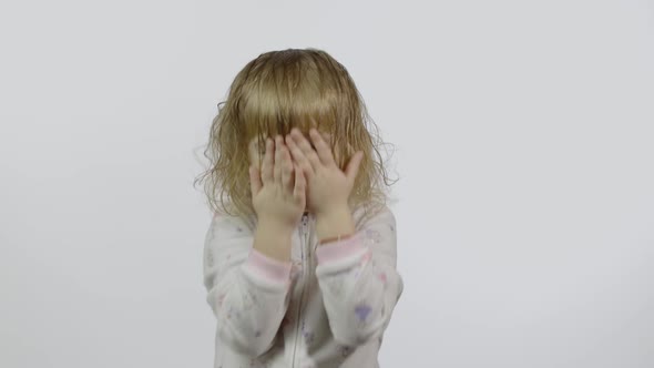 Little Baby Girl in Pajama Is Fooling Around and Make Faces, White Background