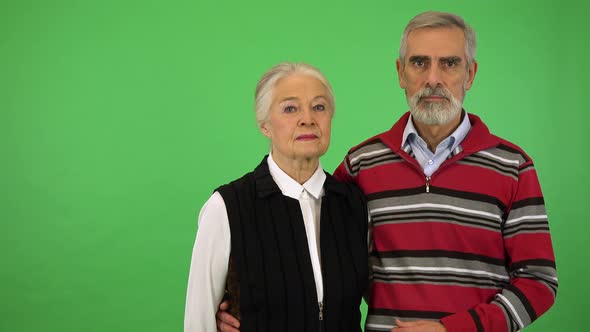 An Elderly Couple Looks Seriously at the Camera - Green Screen Studio