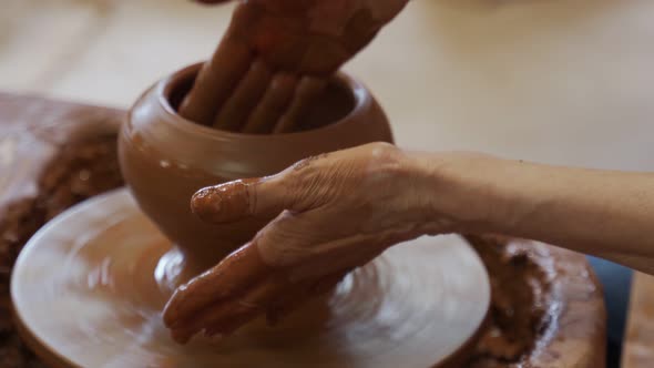 Hands of an Elderly Potter Working with Clay on a Potter's Wheel