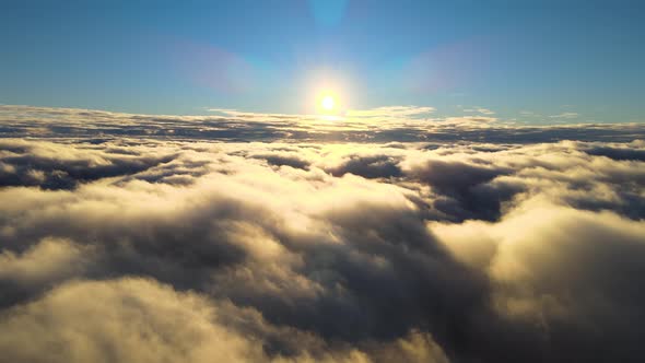 Aerial View From Airplane Window at High Altitude of Dense Puffy Cumulus Clouds Flying in Evening