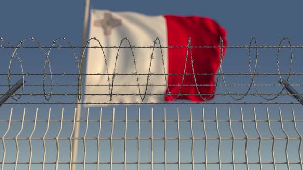 Flying Flag of Malta Behind Barbed Wire Fence