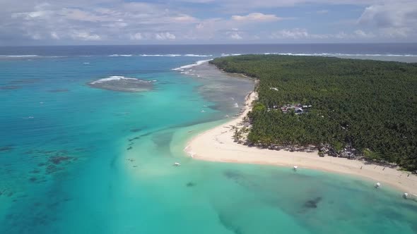 Aerial tracking shot pan right of wonderful island with palm trees and clear blue waters in Siargao,