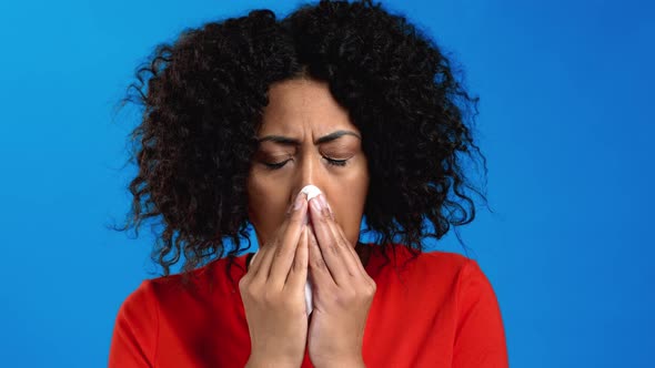 African Woman Sneezes Into Tissue