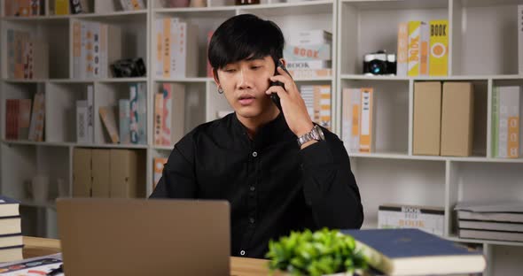 Businessman working on laptop and talking on phone