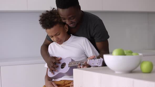 Dad Showing Child How to Play Ukulele Spbi