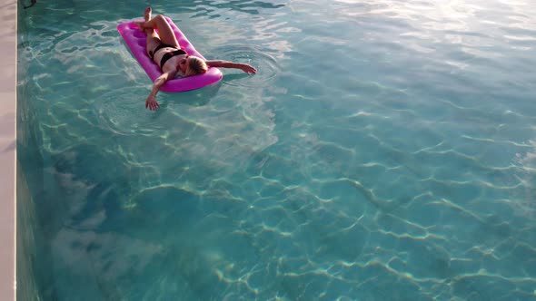 Young Pretty Woman on Air Mattress in the Pool