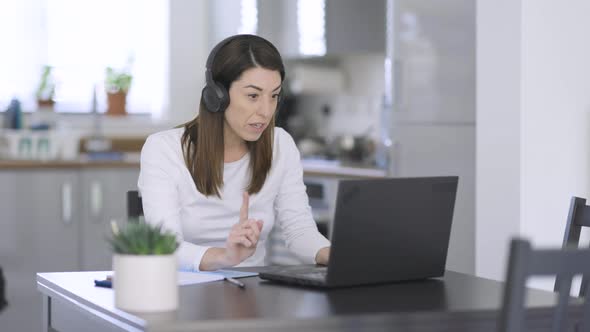 Woman with headphones making video call from home