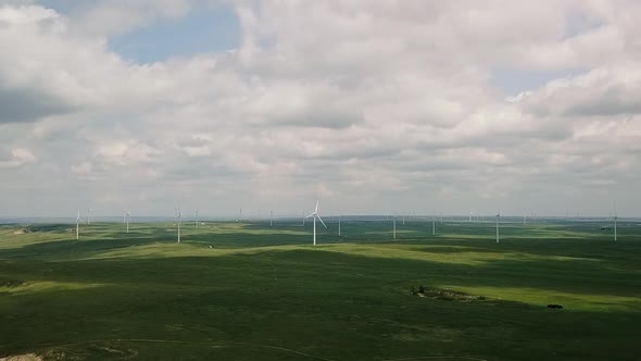 Aerial View of Drone Flying Toward Windmills 