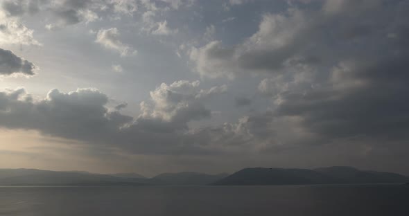 Cloudscape Over A River And Hills.