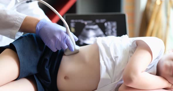 Doctor Conducting Ultrasound Examination of Kidneys to Child in Clinic Closeup  Movie