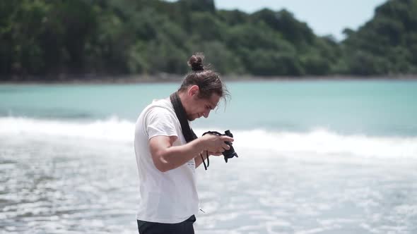 Man with camera shooting sea on coast