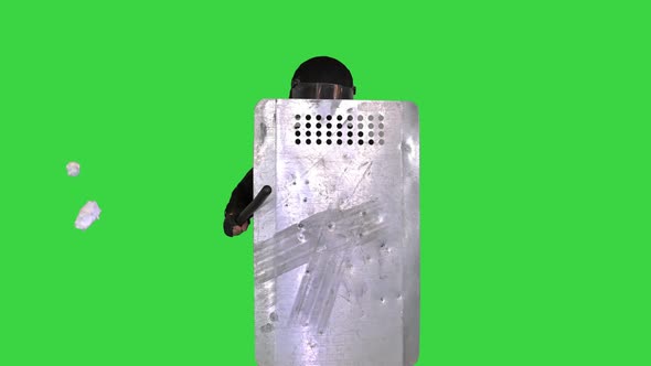 Rubbish Is Thrown in the Riot Policeman with a Shield Up on a Green Screen Chroma Key