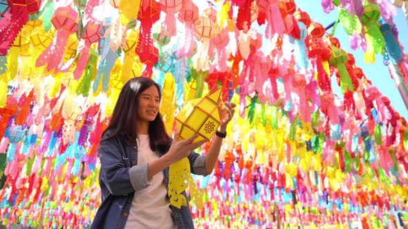 A portrait of Asian woman with colorful lanterns or lamps during travel trip and holidays vacation