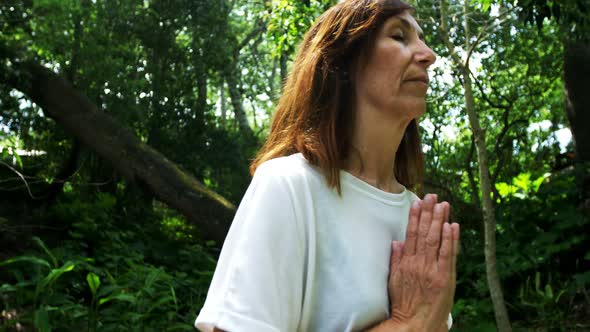 Mature woman performing yoga in the park