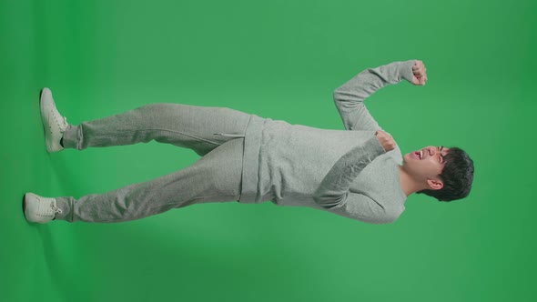 Full Body Of Side View Happy Man Celebrating While Standing In Front Of Green Screen Background