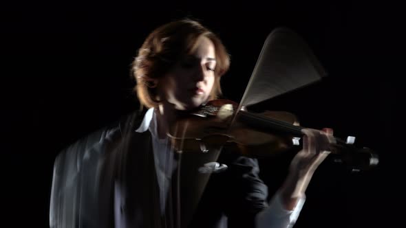 Violinist Performs a Violin in a Black Studio. Black Background