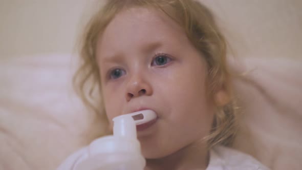 Pretty Girl Has Procedure with Inhaler in Bed Closeup
