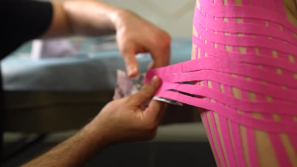 Physiotherapist Applying Kinesio Tape on Female Patient