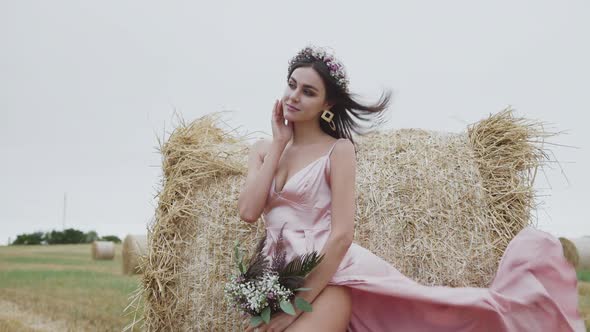 Passionate Lady Poses Gently with Joy at Haystack in Spacious Windy Field