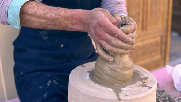 Closeup of Potter Making Clay Vase on Mechanical Pottery Wheel