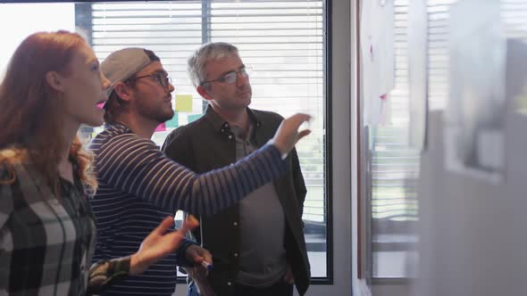 Two men and a woman working in a creative office