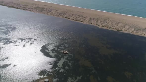 Aerial tracking top down over the fleet near abbotsbury, camera pans up to reveal chesil beach and t