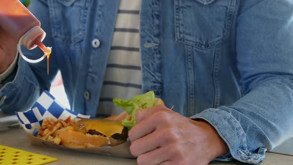 Man pouring sauce on french fries 4k