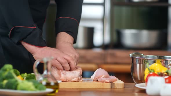 Close Up Male Chef Hands in Uniform Slicing Raw Meat