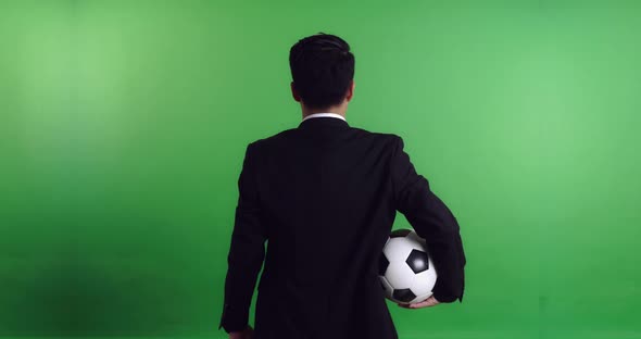 Back of Asian Soccer Manager Holding Soccer Ball