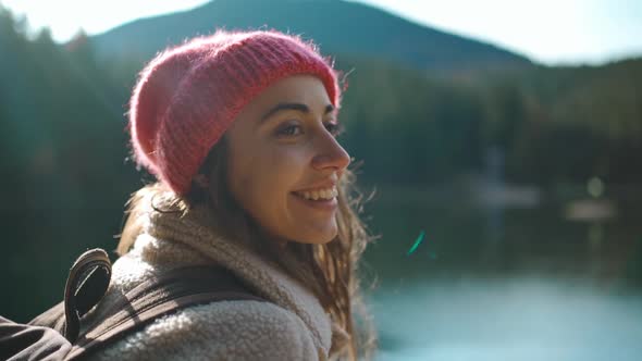 Slow Motion Close Up Portrait Woman Tourist Sits on Wooden Pier By Beautiful Mountain Lake and