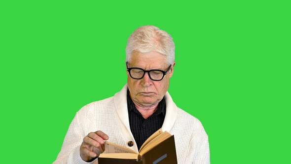 Senior Man Reading a Book on a Green Screen Chroma Key