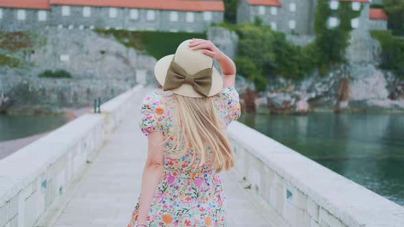 Back View of Long Haired Woman in Hat with Ribbon Bow and Floral Dress