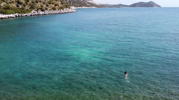 Beautiful girl swimming in Mediterranean sea in Turkey. Drone Angle.