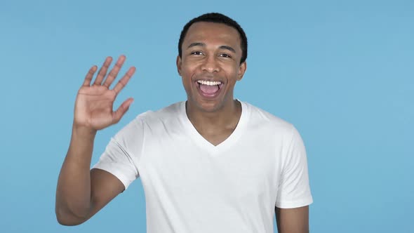 African Man Waving Hand to Welcome Blue Background