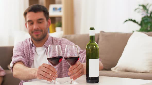 Happy Couple Drinking Red Wine at Home