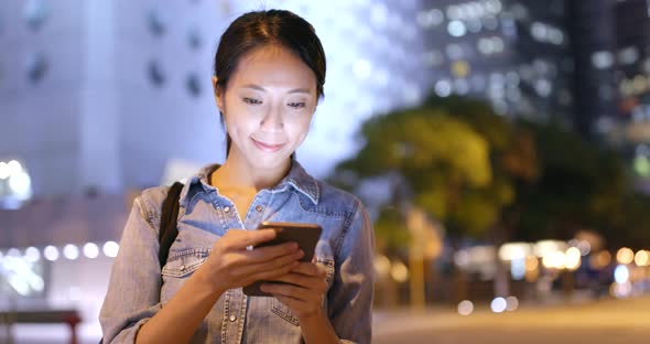 Woman use of smart phone in city at night 