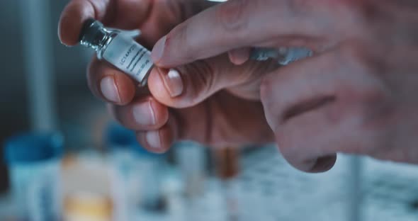 Close up of scientist with cornavirus vaccine in his hands