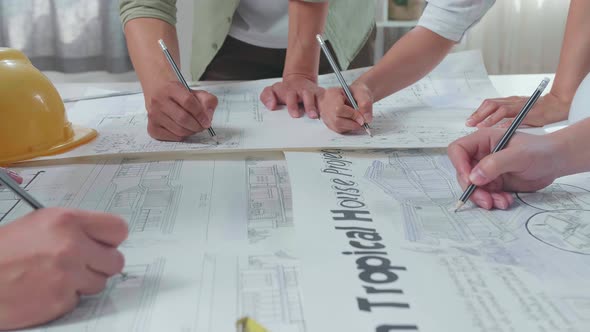 Close Up Of Group Of Asian Engineers Drawing Building Construction At The Office