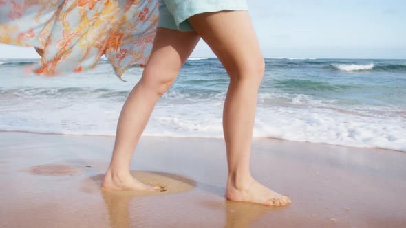 Playful Woman in Beach Dress Waving on Breeze Making Splashes White Foamy Waves