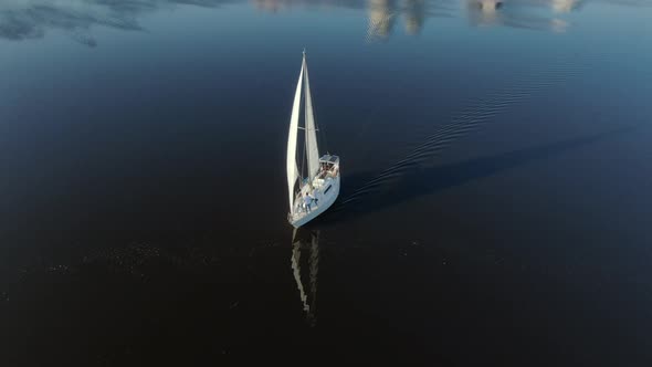 Drone Footage of a Sailing Yacht in the River Near the City