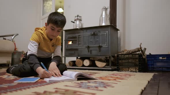 Boy Studying by Wood Stove